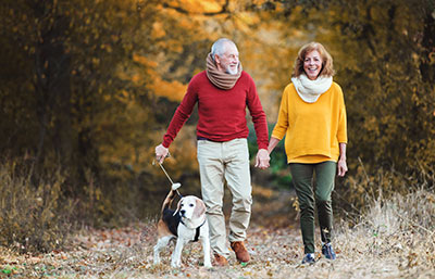 senior couple on walk with dog